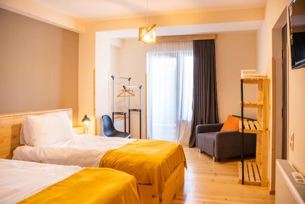Guesthouse twin room with two beds, yellow bed covers and a window