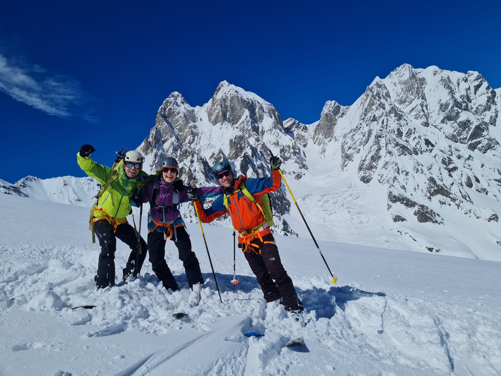 Three riders smiling below snow-covered Svaneti peaks